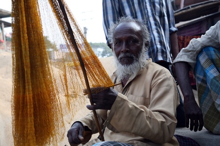 KUMROKHALI, INDIA - JANUARY 12: portrait of a fisherman who weaves a fishing net before the next...