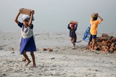 SONAKHALI, INDIA - JANUARY 17 child workers carry bricks carrying it on his head in Sonakhali, West Bengal, India on January 17, 2009.のeditorial素材