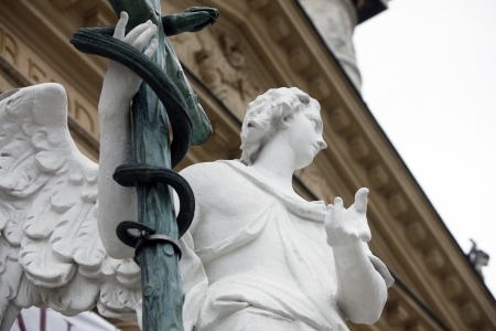Angel statue with cross in front of Karlskirche church in Vienna, Austriaの写真素材