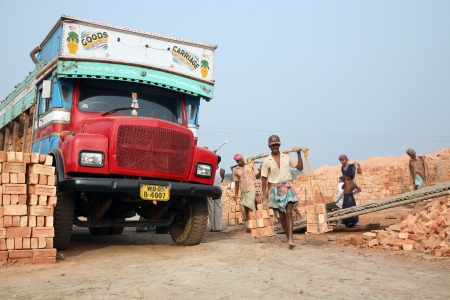 SARBERIA,INDIA, JANUARY 16: Brick field workers carrying complete finish brick from the kiln, and loaded it onto a truck on January 16, 2009 in Sarberia, West Bengal, India.のeditorial素材