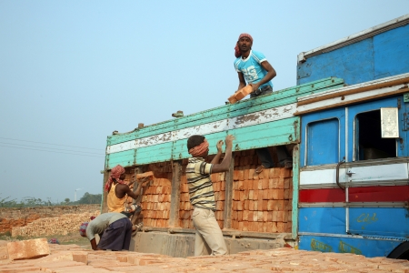 SARBERIA,INDIA, JANUARY 16: Brick field workers carrying complete finish brick from the kiln, and loaded it onto a truck on January 16, 2009 in Sarberia, West Bengal, India.のeditorial素材