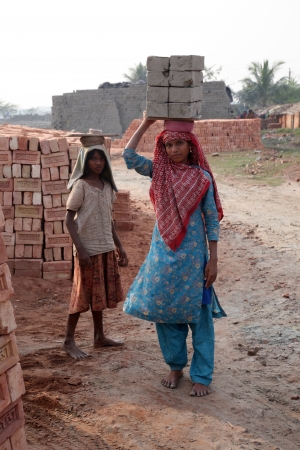 SARBERIA,INDIA, JANUARY 16: Brick field workers carrying complete finish brick from the kiln on January 16, 2009 in Sarberia, West Bengal, India.のeditorial素材