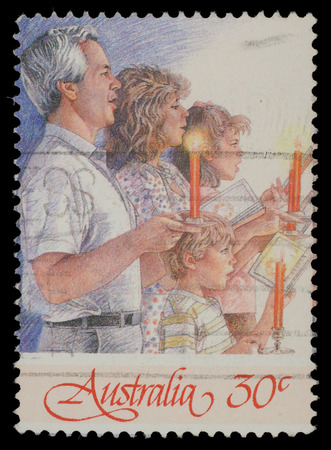 Christmas stamp printed in Australia shows family singing with candles, circa 1988のeditorial素材