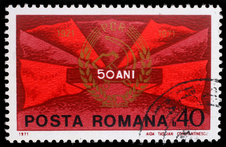Stamp printed in Romania shows Red flags and communist party badge, 50 years P.C.R., circa 1971.のeditorial素材