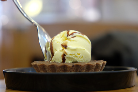 Brownie dessert on a white plate with chocolate syrup and vanilla iceの写真素材