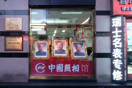 Portraits of three famous Chinese politicians in shop window on famous Wangfujing Street in central Beijing, Chinaのeditorial素材