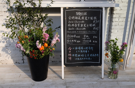 Blackboard with offerings of a restaurant in Beijing 798 Art Zone, Jiuxianqiao Road, Chaoyang in Beijing, Chinaのeditorial素材