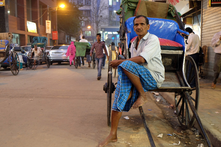 A hand rickshaw puller waits for passengers in his rickshaw in Kolkata on February 10, 2016.