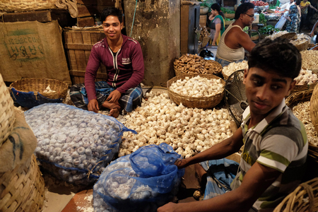 Indian vendor sits behind a large pile of garlic  in New Market in Kolkata on February 11, 2016.のeditorial素材