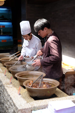 The chefs prepare traditional Chinese food at the restaurant on the Grand Canal, ancient town of Yuehe in Jiaxing, Zhejiang Province, China, February 20, 2016.のeditorial素材