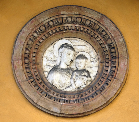 Virgin Mary with baby Jesus, relief on house facade in Modena, Italyの写真素材