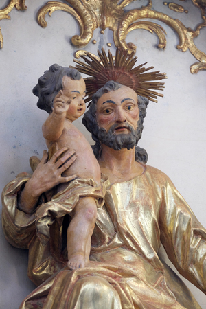 Saint Joseph holding baby Jesus, statue on the altar in Benedictine monastery church in Amorbach, Germanyのeditorial素材