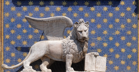 The statue of the winged lion on the St Mark`s Clock tower Torre dell`Orologio on Piazza San Marco, Venice, Italyの写真素材