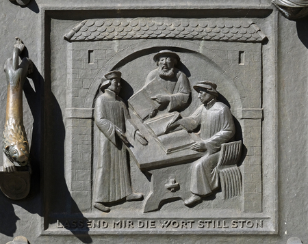 Work on the translation of the Bible, from left: Leo Jud, Theodor Bibiliander and Zwingli, relief on the door of the Grossmunster church in Zurich, Switzerlandのeditorial素材