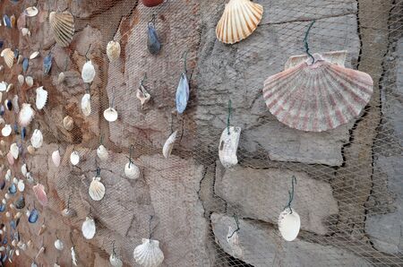 Fishing net decorated with seashell, exposed as decoration in front of the restaurant in Icici,...
