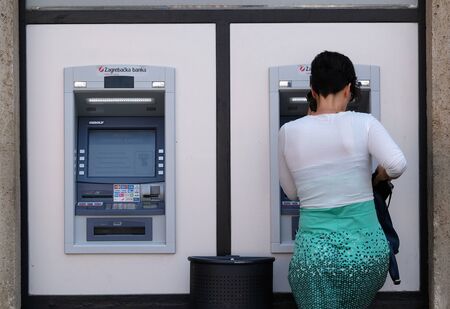 Girl withdrawing money from an ATM machine in Zagreb city centerの写真素材