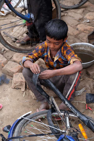 Mechanic in the workshop repair the tire on a bicycle, Kumrokhali, West Bengalのeditorial素材