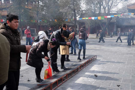 Worshippers holding incense sticks pray at Yonghegong Lama Temple in Beijing, Chinaのeditorial素材