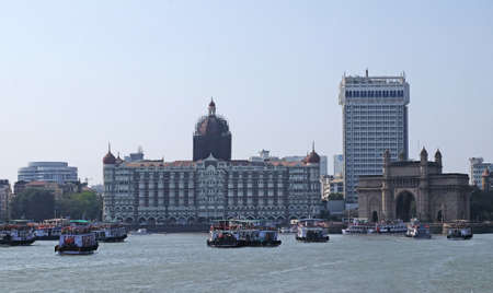 Taj Mahal hotel, Gateway of India and tourist boats in water of Arabian Sea in Mumbai, Indiaのeditorial素材
