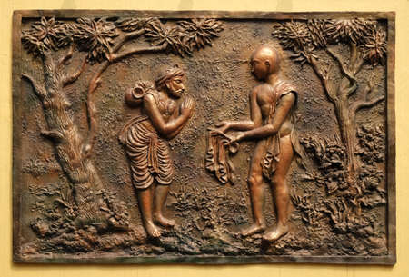 Gift of the half of the Devadusya (divine cloth given by Indra) to a poor Brahmin, Street bas relief on the wall of Jain Temple (also called Parshwanath Temple) in Kolkata, West Bengal, Indiaのeditorial素材