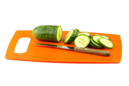 Sliced ââcucumber on the board with a knife.の写真素材