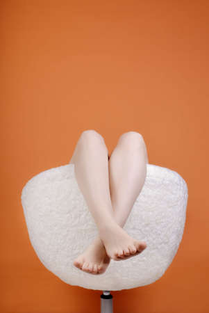 Female feet in an armchair with copy spaceの写真素材