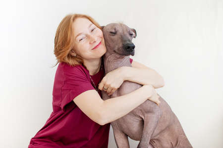 A woman hugging with a Mexican Hairless Dogの写真素材