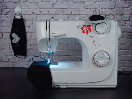 White sewing machine and black hand-made masks.