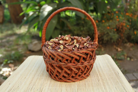 Rattan basket with walnuts cores standing on a bamboo napkin in the gardenの写真素材