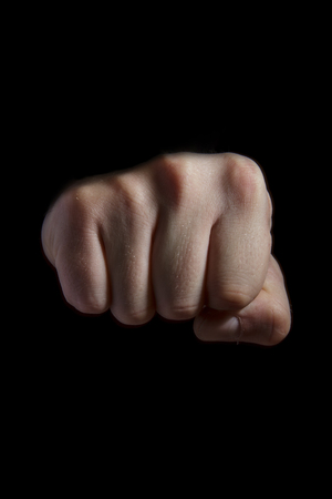 Male fist on black background. isolate punch