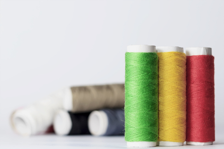 Accessories for sewing lie on a white background. Multicolored coils of threadsの写真素材