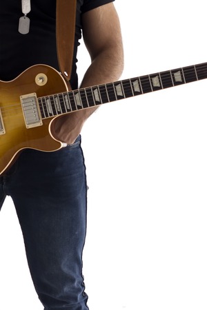 A man with an electric guitar Leaning against a cement wall Happy and relaxed Waiting for the showの写真素材