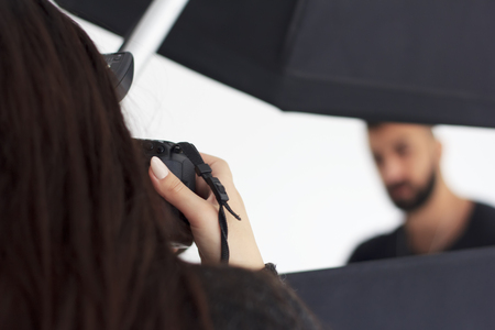 Photographing in the studio, a photographer and a model enjoy filming.の写真素材