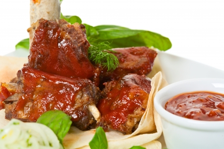 Grilled  ribs with vegetables and sauce on the plate の写真素材