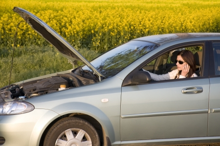 woman with damaged car calling for helpの写真素材