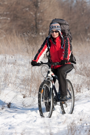 Smiling snow biker on the sunsetの写真素材