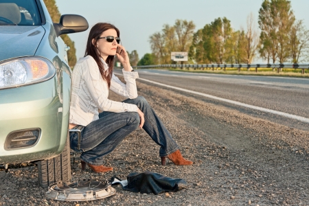 woman with damaged car calling for helpの写真素材