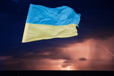 Ukrainian state flag is flying on the background of a stormy sky , lightning and tornadoes.の写真素材