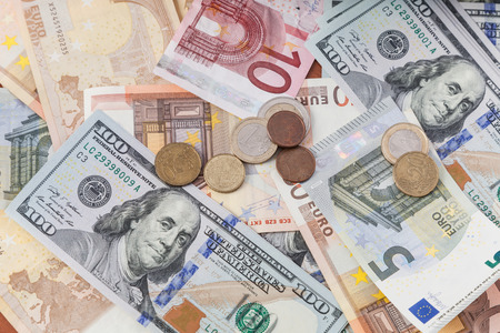 Euro and dollar bills with coinsの写真素材