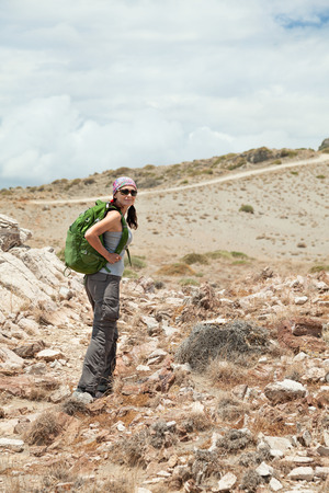 Adult brunette woman hiking and backpacking in beautiful desert and rocky landscape of south Crete, Greece.の写真素材
