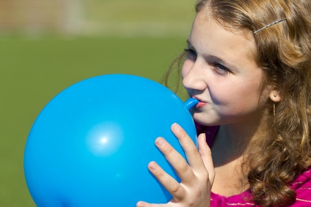 teen girl inflates the balloon outdoorsの写真素材