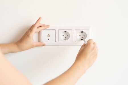 non-female work. repair and decoration. woman repairs outlets in a new apartment