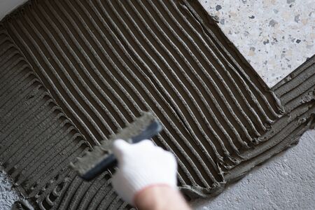 Repair and decoration of apartments and houses. Professionals lay porcelain tiles on the floor in the bathroom.の写真素材