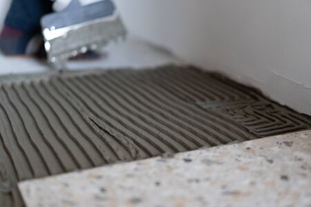 Repair and decoration of apartments and houses. Professionals lay porcelain tiles on the floor in the bathroom.の写真素材