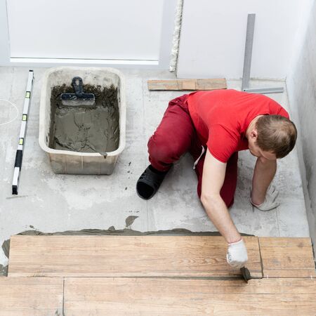 repair and decoration. the tiler puts the porcelain tiles on the floor in the apartmentの写真素材