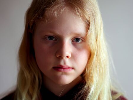 portrait of a simple serious girl on a gray backgroundの写真素材