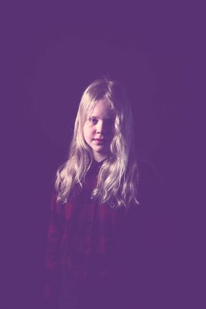 portrait of a blonde teen girl on a black background in studioの写真素材