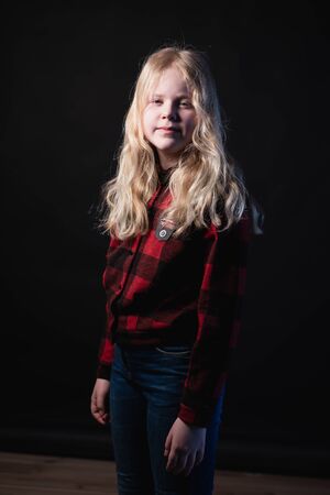 portrait of a blonde teen girl on a black background in studioの写真素材