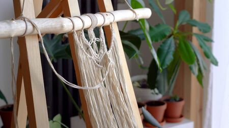 stay at home. work during the quarantine - a girl in the living room mural weaving of the ropes in the macrame technique.の写真素材