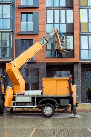 Belarus, Minsk - 27 05 2020 - city building. workers repair the facade of a residential building using construction equipmentのeditorial素材